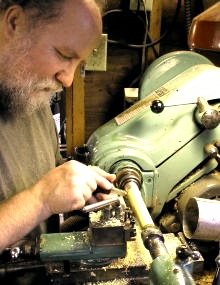[Photo of Casey Burns turning a boxwood flute foot joint at the lathe]