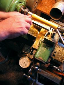 [turning a boxwood flute foot joint at the lathe]